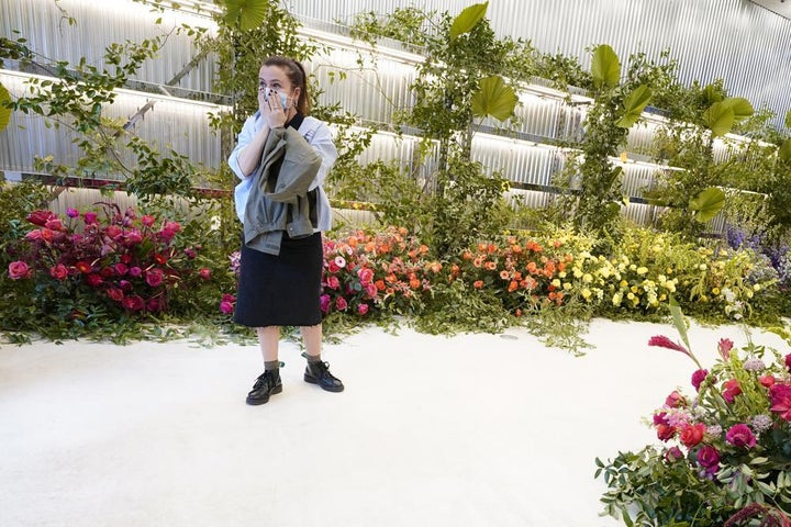 A shopper at the Off-White Label store, is overcome by the flowers left in memory of Virgil Abloh, the artistic director for Louis Vuitton's menswear on Nov. 30, in Miami.