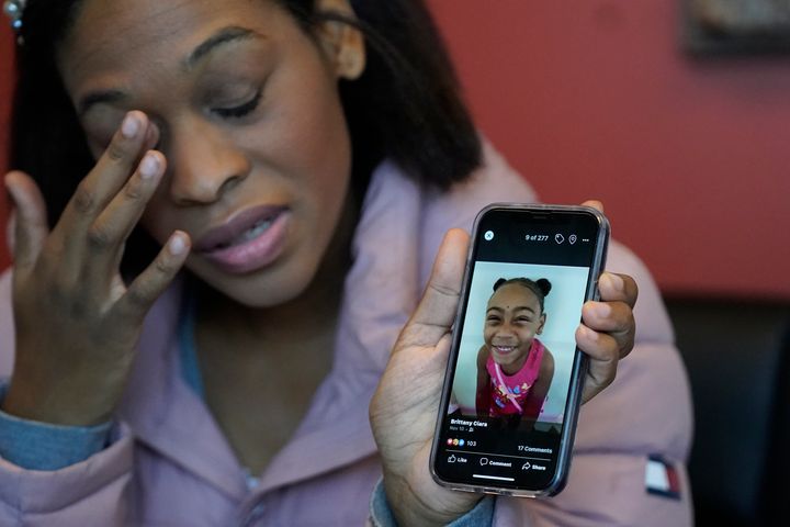 Η Μπρίτανι Τίχενορ-ΚΟξ κρατάει το κινητό της με τη φωτογραφία της κόρης της Ίζι, την ημέρα που δίνει συνέντευξη στο Associated Press στις 29 Νοεμβρίου 2021. (AP Photo/Rick Bowmer)