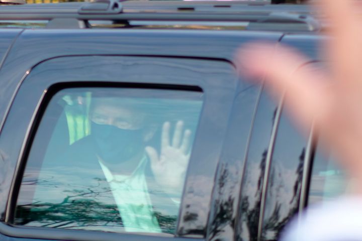 Then-President Donald Trump drives past supporters gathered outside Walter Reed National Military Medical Center in Bethesda, Maryland, on Oct. 4, 2020, after he was admitted to the hospital for a COVID-19 infection. 