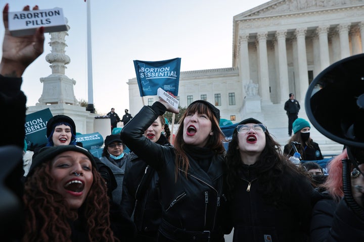 Demonstrators Alana Edmondson, Lila Bonow, Amelia Bonow and Aiyana Knauer celebrate after taking abortion pills while demonstrating in front of the U.S. Supreme Court as the justices hear arguments Wednesday.