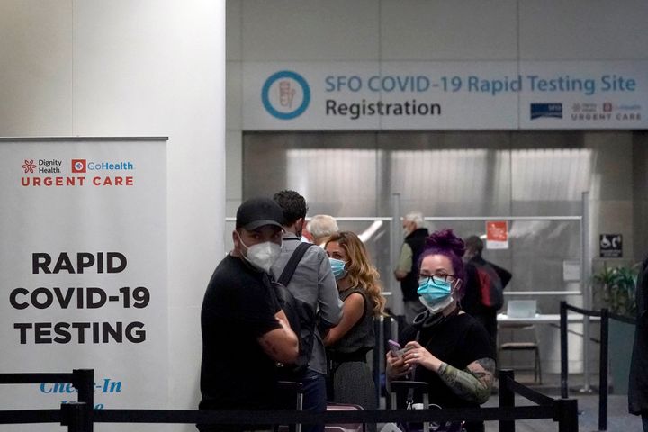 The nation's first case of the omicron coronavirus variant was detected in a San Francisco resident, the CDC announced Wednesday. United Airlines passengers wait in line to register at the SFO COVID-19 rapid testing site at San Francisco International Airport in San Francisco.