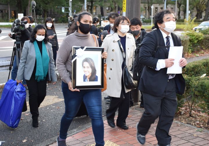 告訴状提出のため名古屋地検に向かうウィシュマさんの妹のポールニマさん（左から2人目）、遺族側代理人の指宿昭一弁護士（右）＝11月9日午後、名古屋市