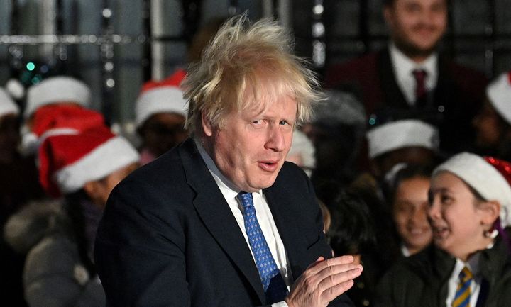 Prime Minister Boris Johnson applauds the choir as he attends the switch on of the Christmas tree lights outside 10 Downing Street last night.
