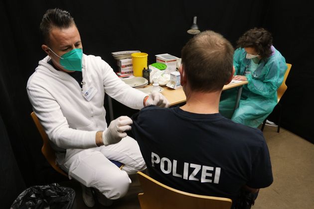 02 December 2021, North Rhine-Westphalia, Hilden: A police officer gets a booster vaccination. The police...