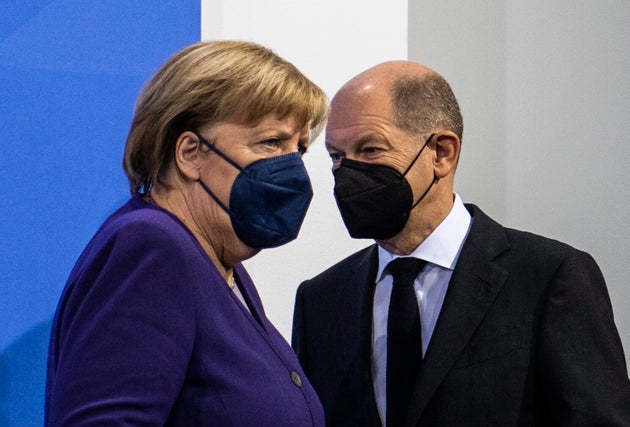 La chancelière allemande Angela Merkel et son successeur désigné Olaf Scholz arrivent pour une conférence de presse à la suite d