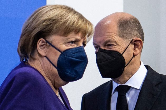 German Chancellor Angela Merkel (L) and her designated successor Olaf Scholz arrive for a press conference...