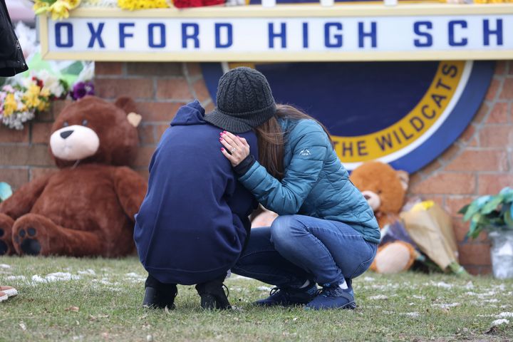 People embrace as they visit a makeshift memorial outside of Oxford High School on Dec. 01, 2021, in Oxford, Michigan.