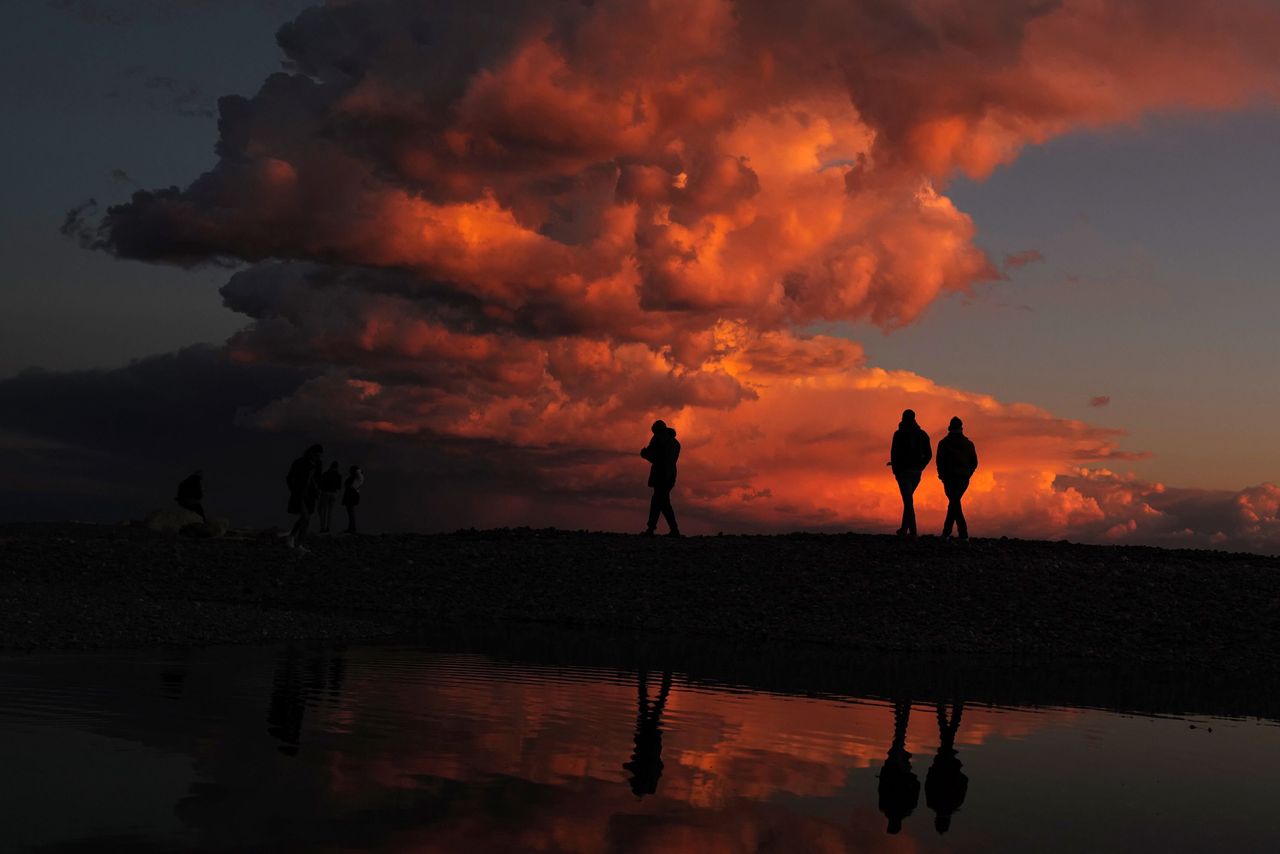 People walk on the beach at the sunset in French city of Nice on Monday.