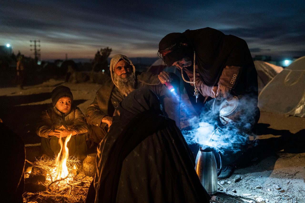 A family prepares tea on Saturday outside the Directorate of Disaster office in in Herat, Afghanistan, where they are camped. About 2,000 internally displaced people left Allahyar village in Ghor province because of a drought and are seeking help from the regional government in Herat.
