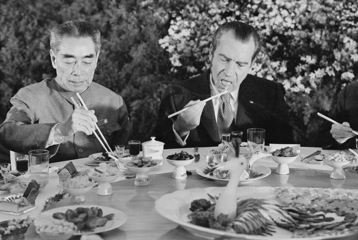 (Original Caption) SHANGHAI, CHINA: Pres. Richard Nixon digs in with chopsticks as he sits beside Chinese Premier Chou En-lai during farewell banquet on the eve of Nixon's departure from China Feb. 27th.