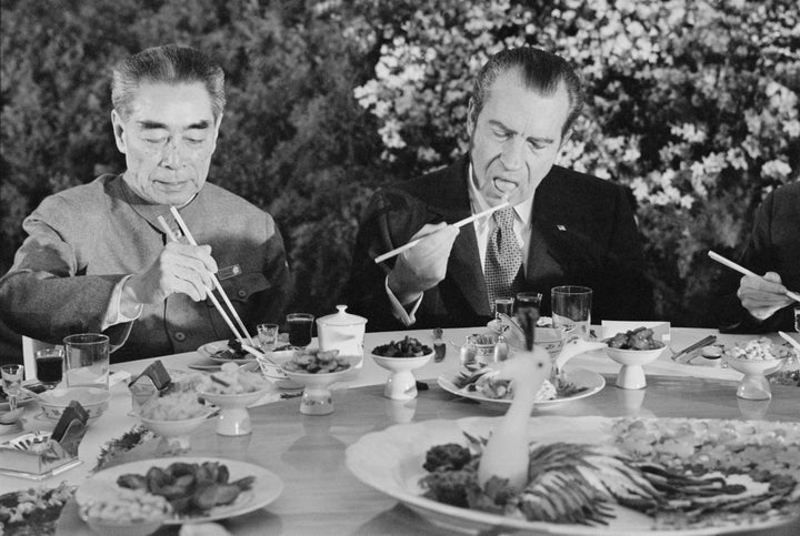 (Original Caption) SHANGHAI, CHINA: Pres. Richard Nixon digs in with chopsticks as he sits beside Chinese Premier Chou En-lai during farewell banquet on the eve of Nixon's departure from China Feb. 27th.