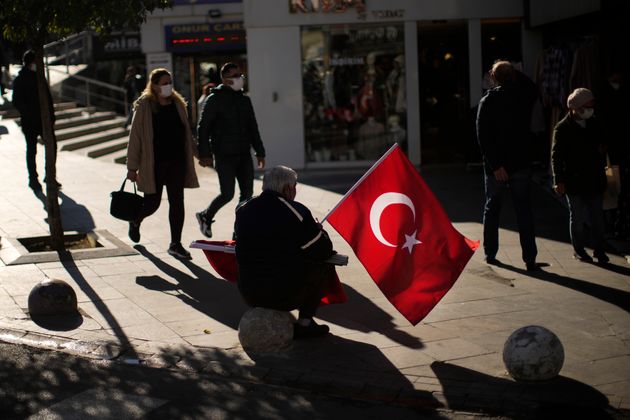 2 Δεκεμβρίου 2021 - Ο εικονιζόμενος χτυπημένος από την οικονομική κρίση πουλάει τούρκικες σημαίες για...