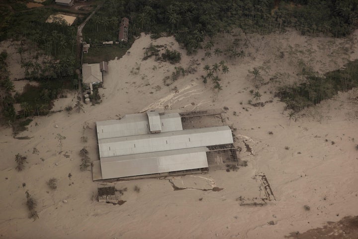 A factory building is covered by ash from the eruption of Mount Semeru in Lumajang district, East Java province, Indonesia, Sunday, Dec. 5, 2021. The death toll from eruption of the highest volcano on Indonesia's most densely populated island of Java has risen with scores still missing, officials said Sunday as rain continued to pound the region and hamper the search.(AP Photo/Trisnadi)