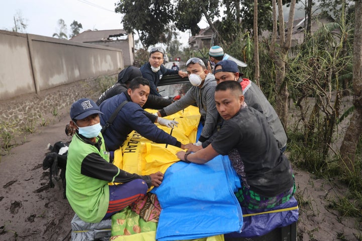 Indonesian rescuers and villagers evacuate a victim on a car in an area affected by the eruption of Mount Semeru in Lumajang, East Java, Indonesia, Sunday, Dec. 5, 2021. The highest volcano on Indonesia’s most densely populated island of Java spewed thick columns of ash, searing gas and lava down its slopes in a sudden eruption triggered by heavy rains on Saturday. (AP Photo/Trisnadi)