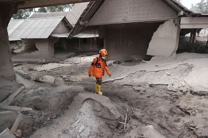 A rescuer walks in an area hit by the eruption of Mount Semeru in Lumajang district, East Java province, Indonesia, Sunday, Dec. 5, 2021. The death toll from eruption of the highest volcano on Indonesia's most densely populated island of Java has risen with scores still missing, officials said Sunday as rain continued to pound the region and hamper the search.(AP Photo/Trisnadi)