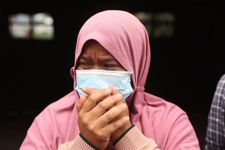 A woman weeps as her house was destroyed by the eruption Mount Semeru in Lumajang district, East Java province, Indonesia, Sunday, Dec. 5, 2021. The death toll from eruption of the highest volcano on Indonesia's most densely populated island of Java has risen with scores still missing, officials said Sunday as rain continued to pound the region and hamper the search.(AP Photo/Trisnadi)