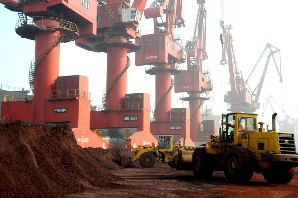Workers transport soil containing rare earth elements for export at a port in Lianyungang, Jiangsu province,...