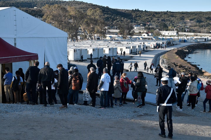 Refugees line up outside the Moria detention centre for migrants and refugees near Mytilene during the pope's visit.