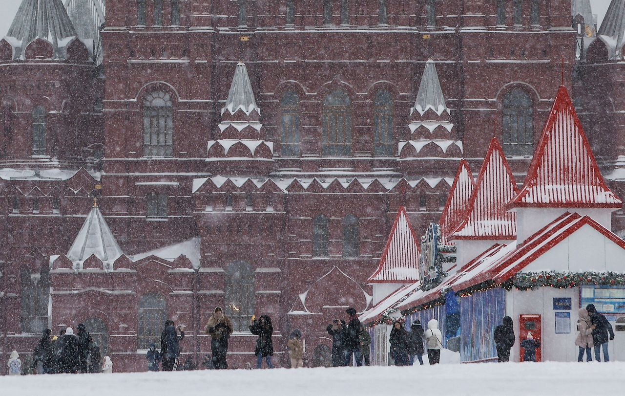 Κόσμος περπατάει στην Κόκκινη Πλατεία κατά τη διάρκεια της έντονης χιονόπτωσης.