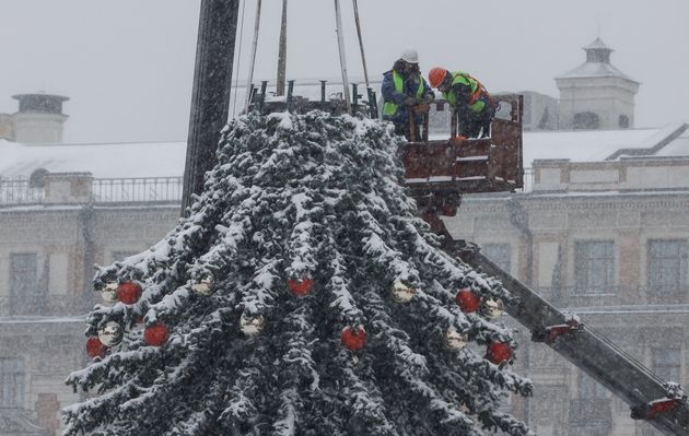 Δημοτικοί υπάλληλοι στολίζουν το χριστουγεννιάτικο δέντρο κατά την διάρκεια της έντονης χιονόπτωσης.