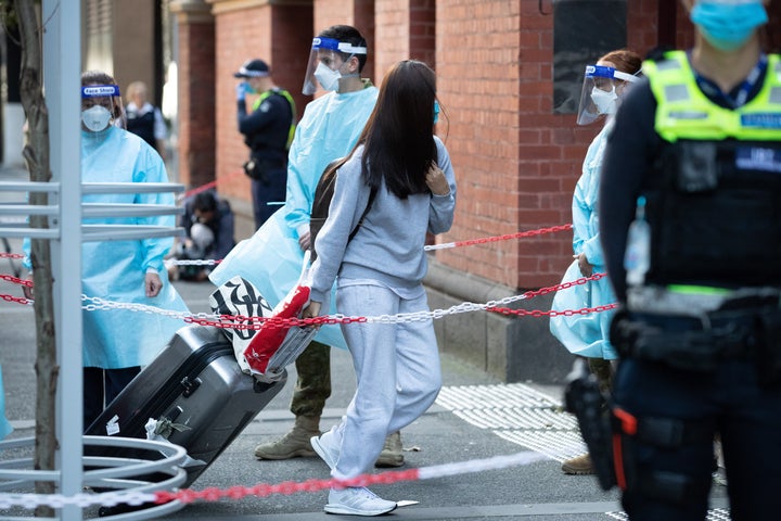 International travelers depart a bus and enter quarantine at the Intercontinental Hotel on April 8, 2021, in Melbourne, Australia.