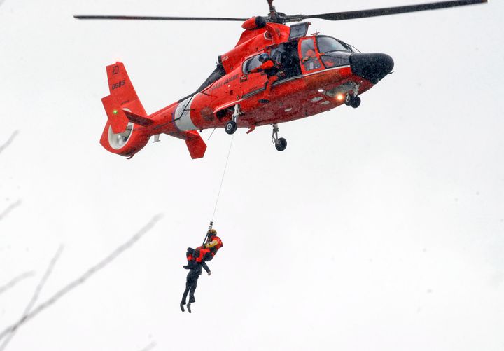 A U.S. Coast Guard diver pulls a body from a submerged vehicle stuck in rushing rapids just yards from the brink of Niagara Falls. 