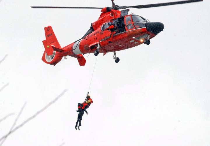 A U.S. Coast Guard diver pulls a body from a submerged vehicle stuck in rushing rapids just yards from the brink of Niagara Falls.