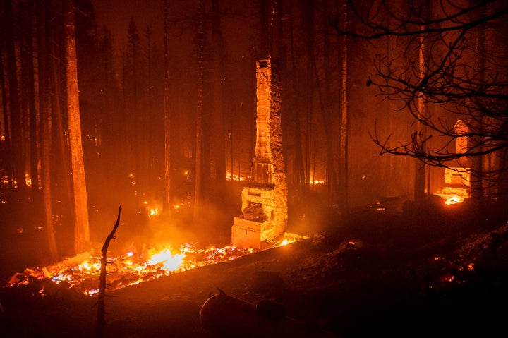 Seen in a long camera exposure, chimneys stand at residences leveled by the Caldor Fire along Highway 50 on Aug. 29, 2021, in Eldorado National Forest, Calif. A father and son have been arrested on suspicion of starting a massive California wildfire that forced tens of thousands to flee the Lake Tahoe area earlier this year, officials said Wednesday, Dec. 8, 2021. (AP Photo/Noah Berger, File)