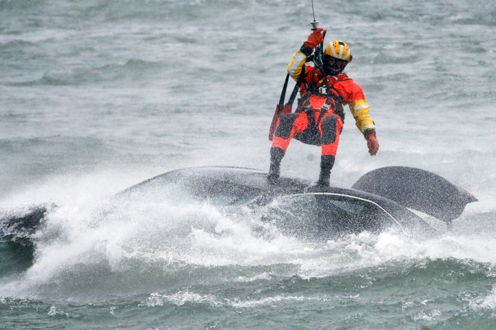上空から救助を試みる沿岸警備隊の潜水士