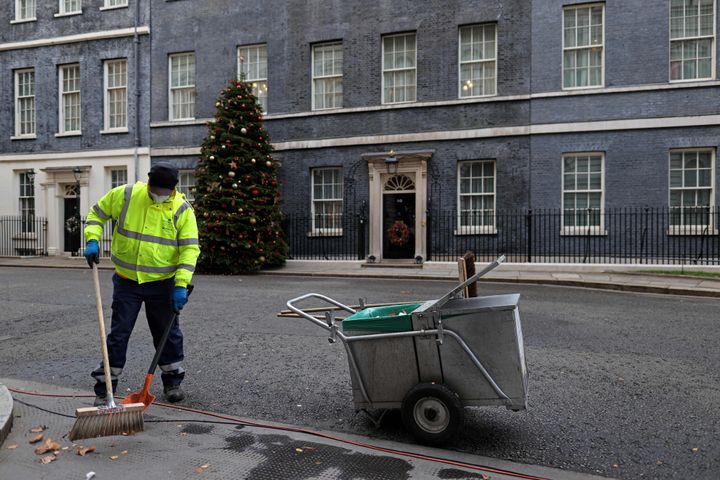 A City of Westminster worker cleans the street in front of 10 Downing Street on December 8, 2021