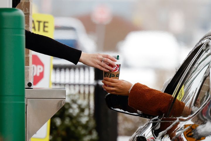 A cup is handed through a Starbucks drive-thru window in Cheektowaga, a suburb of Buffalo, New York, on Dec. 8.