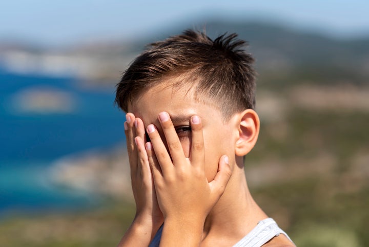 shy boy covering his face