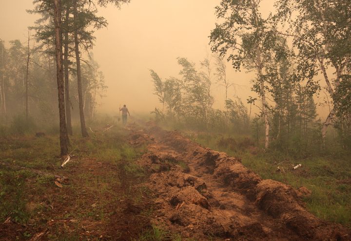 Κάτοικος στο χωριό Μαγκαράς στην περιοχή της Γιακούτια της Ρωσίας κατά τη διάρκεια των εργασιών για την κατάσβεση δασικής πυρκαγιάς, τον Ιούλιο του 2020.