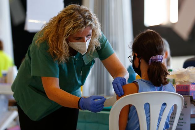 Una enfermera pone la vacuna contra el coronavirus a una niña en