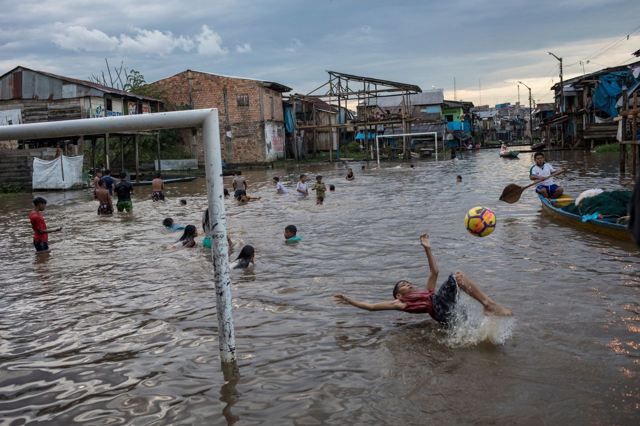 Μικρά παιδιά παίζουν ποδόσφαιρο σε αυτοσχέδιο γήπεδο, καλυμμένο από λασπόνερα, μετά από τεράστιες πλημμύρες - Ικίτος, Περού (20/3/2021) 