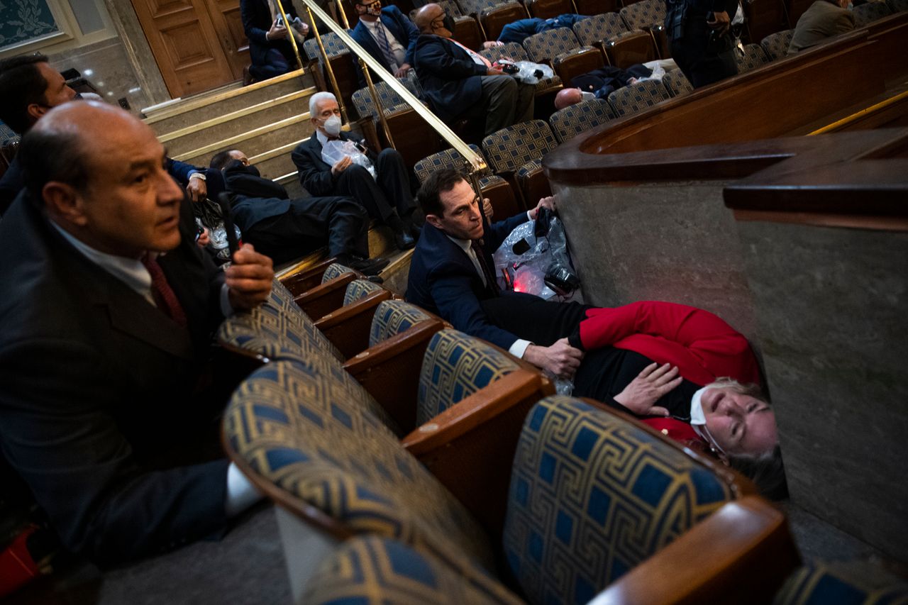 In this photo that went viral on Jan. 6, Wild is lying on the ground as Rep. Jason Crow comforts her.