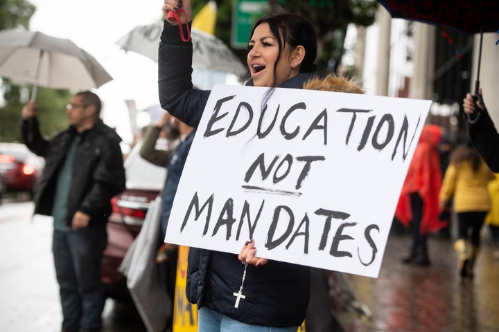 A parent of an eleventh-grader joins a rally opposing LAUSD's student vaccine mandate outside the district office in Los Angeles on Tuesday.