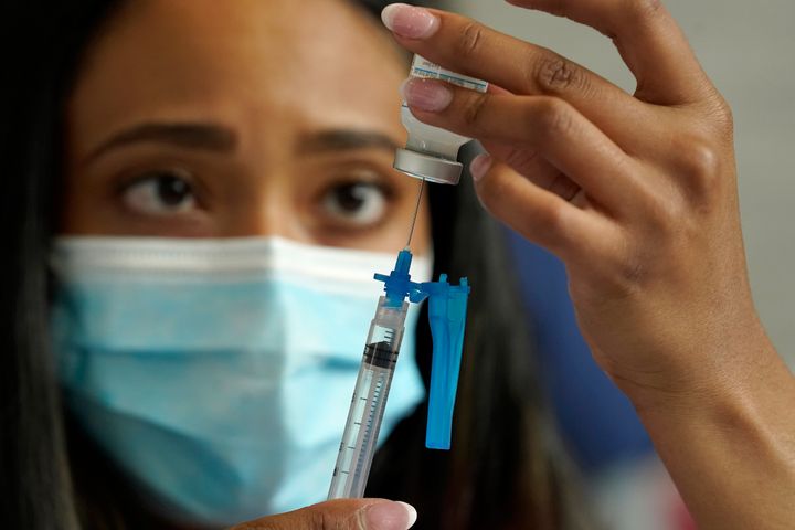 A nurse draws a Moderna COVID-19 vaccine into a syringe at a mass vaccination clinic in Massachusetts. COVID-19 cases have been steadily rising in the U.S. since late October.