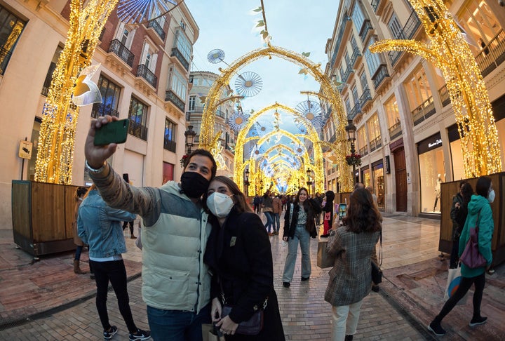 Una pareja se hace fotos ante la decoración navideña de la Calle Larios, en Málaga.
