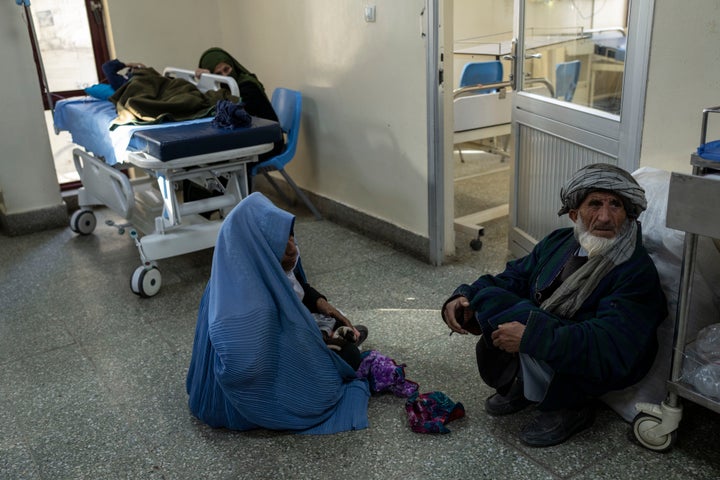 A woman holds her child while sitting on the floor of the emergency ward of the Indira Gandhi Children's Hospital in Kabul.