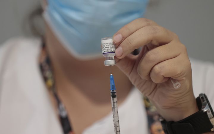 Una profesional sanitaria prepara una dosis de la vacuna en el hospital madrileño Isabel Zendal.