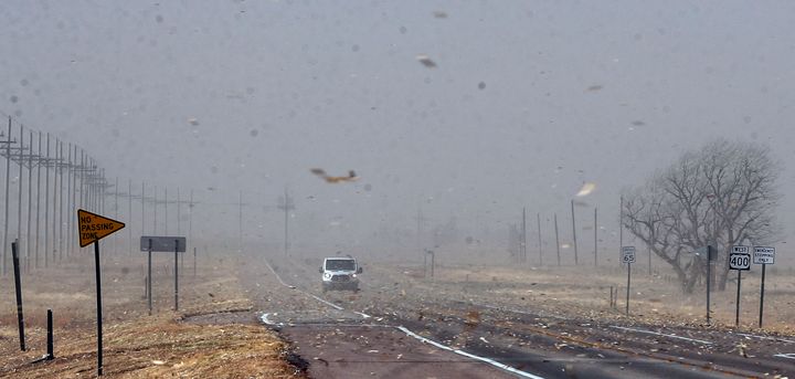 Debris from nearby farm fields swirls around on Highway 400 in Kansas.