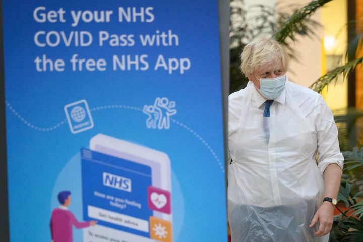 Boris Johnson walks past a poster advertising the NHS Covid Pass during a visit to a vaccination centre in Ramsgate, Kent.