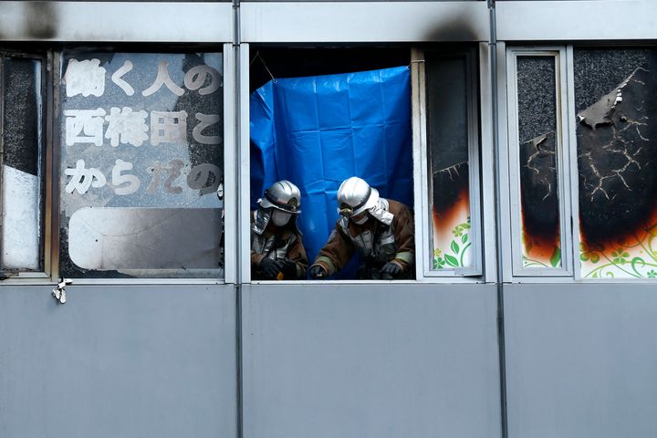 Firefighters investigate a fire at an office building, after the blaze was extinguished in Osaka on December 17,2021. (Photo by Buddhika Weerasinghe / AFP) (Photo by BUDDHIKA WEERASINGHE/AFP via Getty Images)
