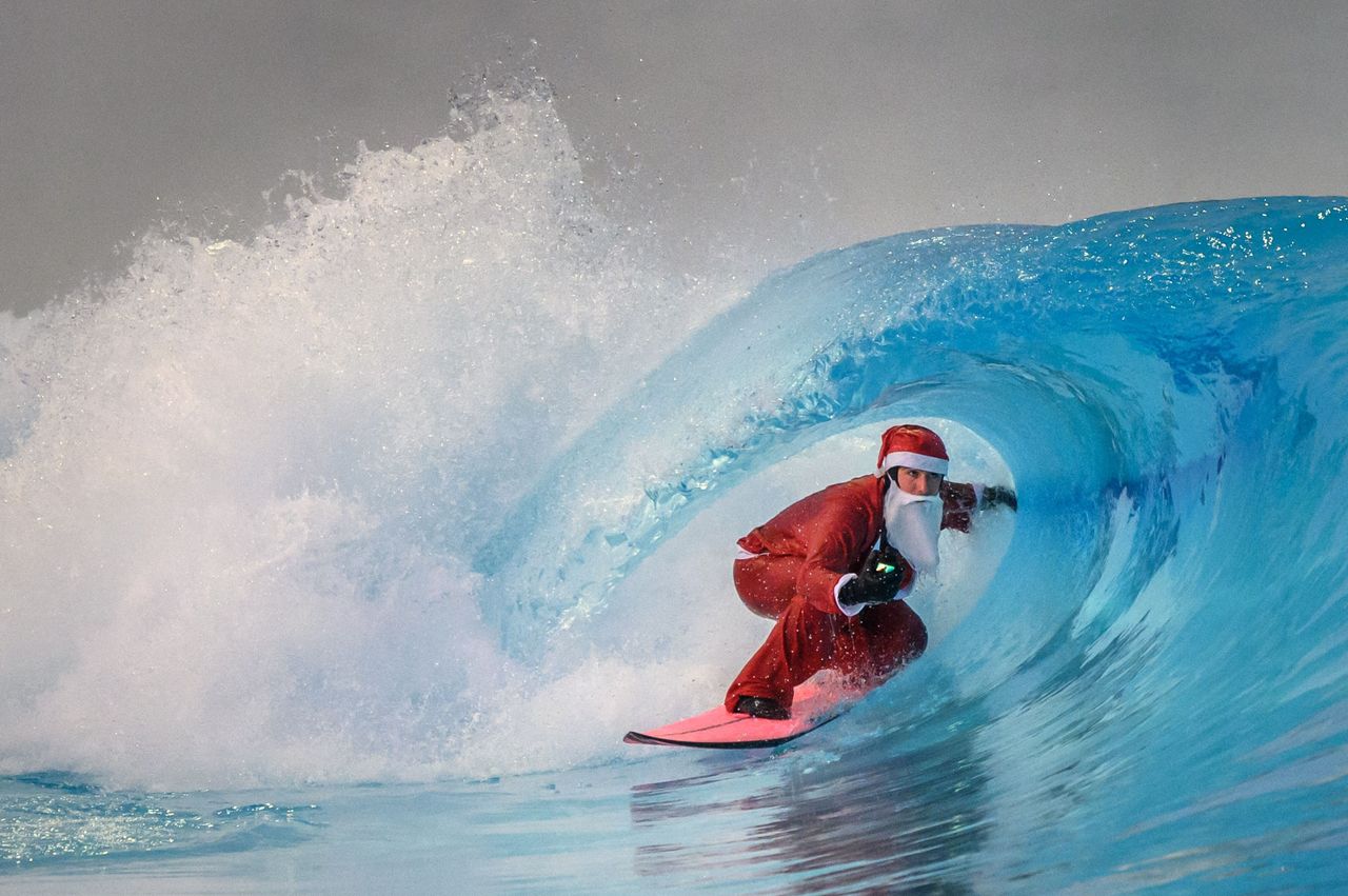 A surfer dressed as Santa Claus rides an artificial wave in a surf wave pool surrounded by Swiss Alps, in Sion, Switzerland, on Wednesday.
