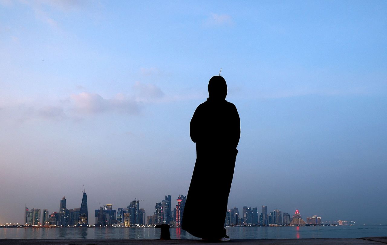 A woman stands by the waterfront overlooking the towered skyline of Qatar's capital, Doha, on Monday.