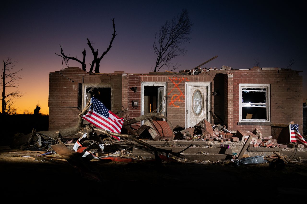 American flags are seen near a damaged home on Thursday in Mayfield, Kentucky. 