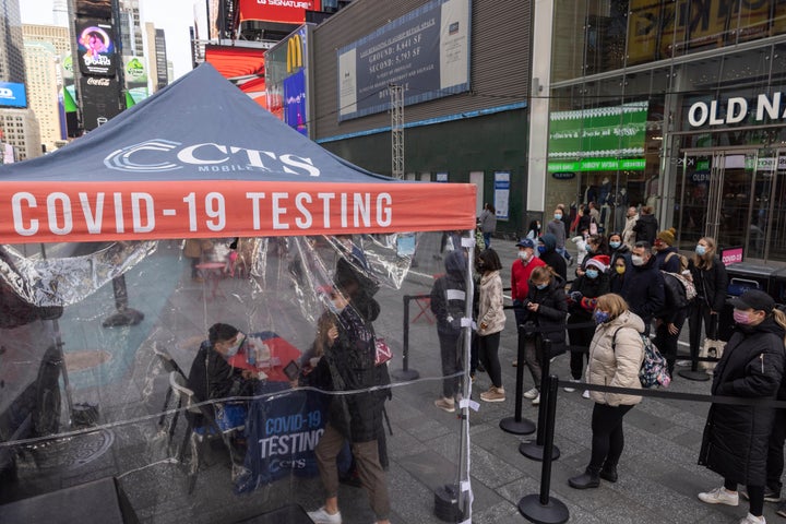 People wait in line to get tested for COVID-19 at a mobile testing site in Times Square on Friday, Dec. 17, 2021, in New York.