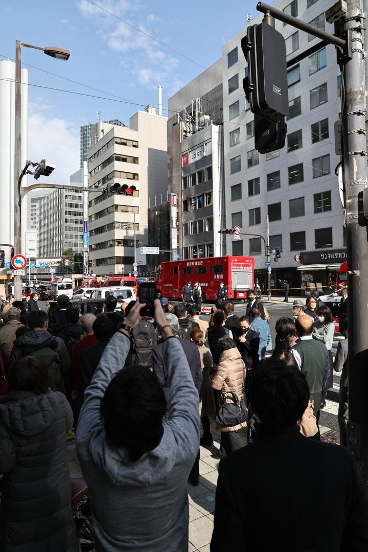 通行する人々で混雑するビル火災の現場付近