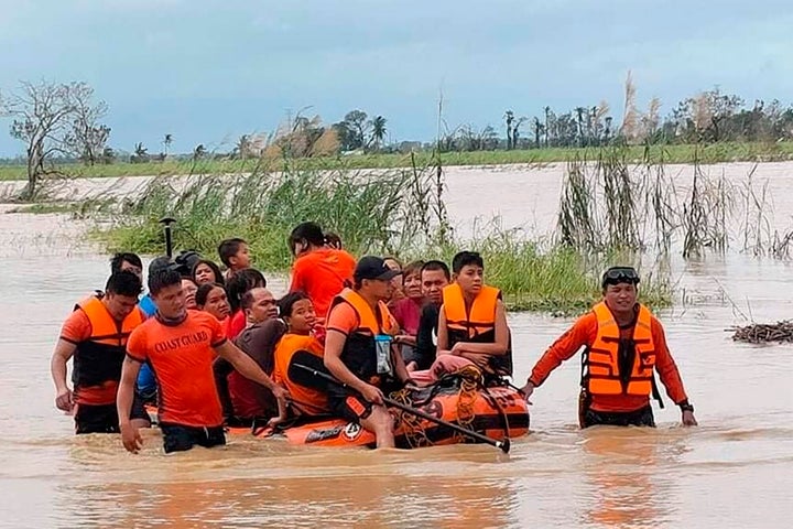 Los equipos de rescate ayudaron a los residentes que quedaron atrapados en sus hogares después de que las inundaciones causadas por el tifón Rai inundaron su aldea el viernes.